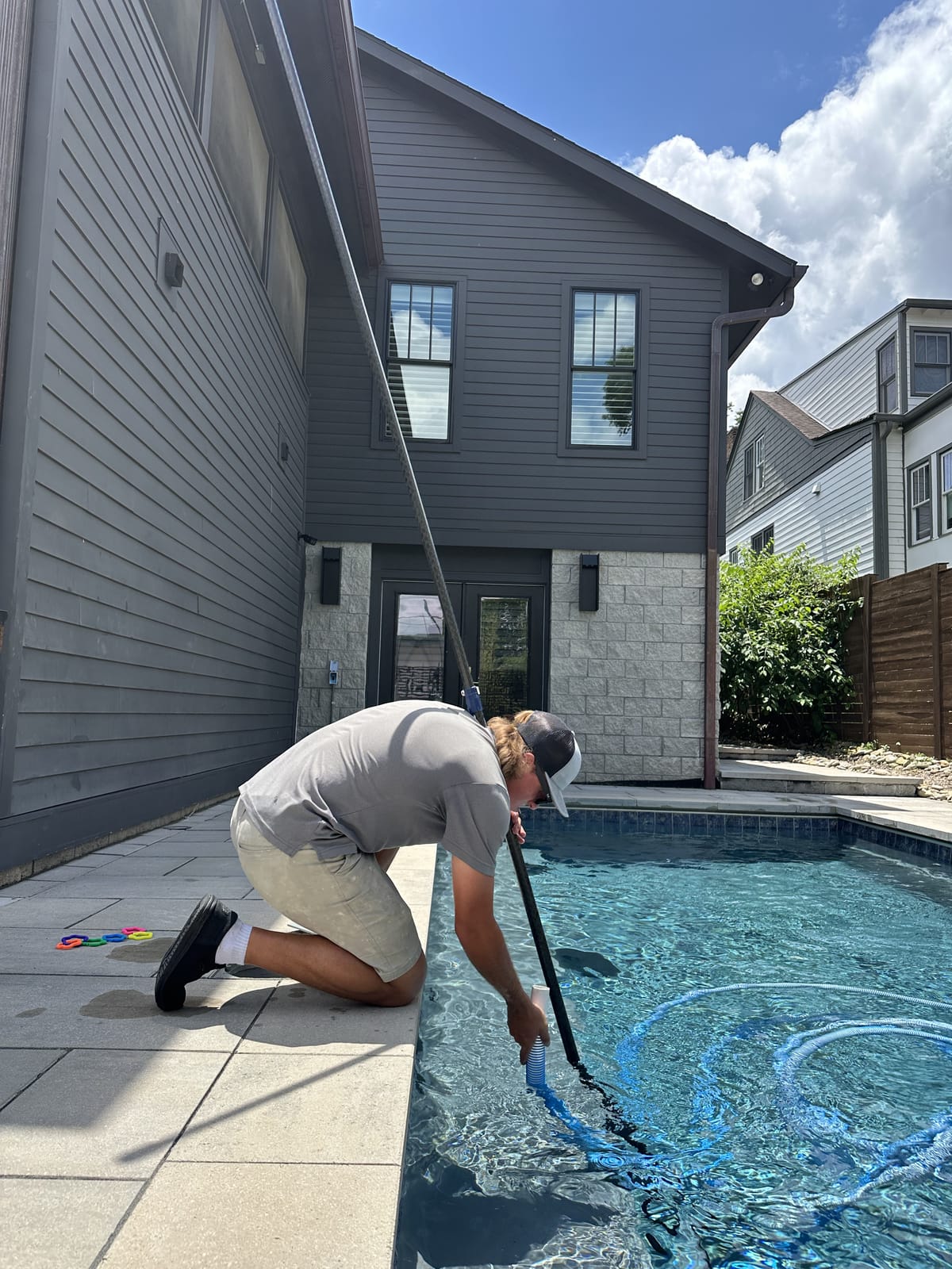 Bright Water technician setting up a vacuum hose during a weekly maintenance visit