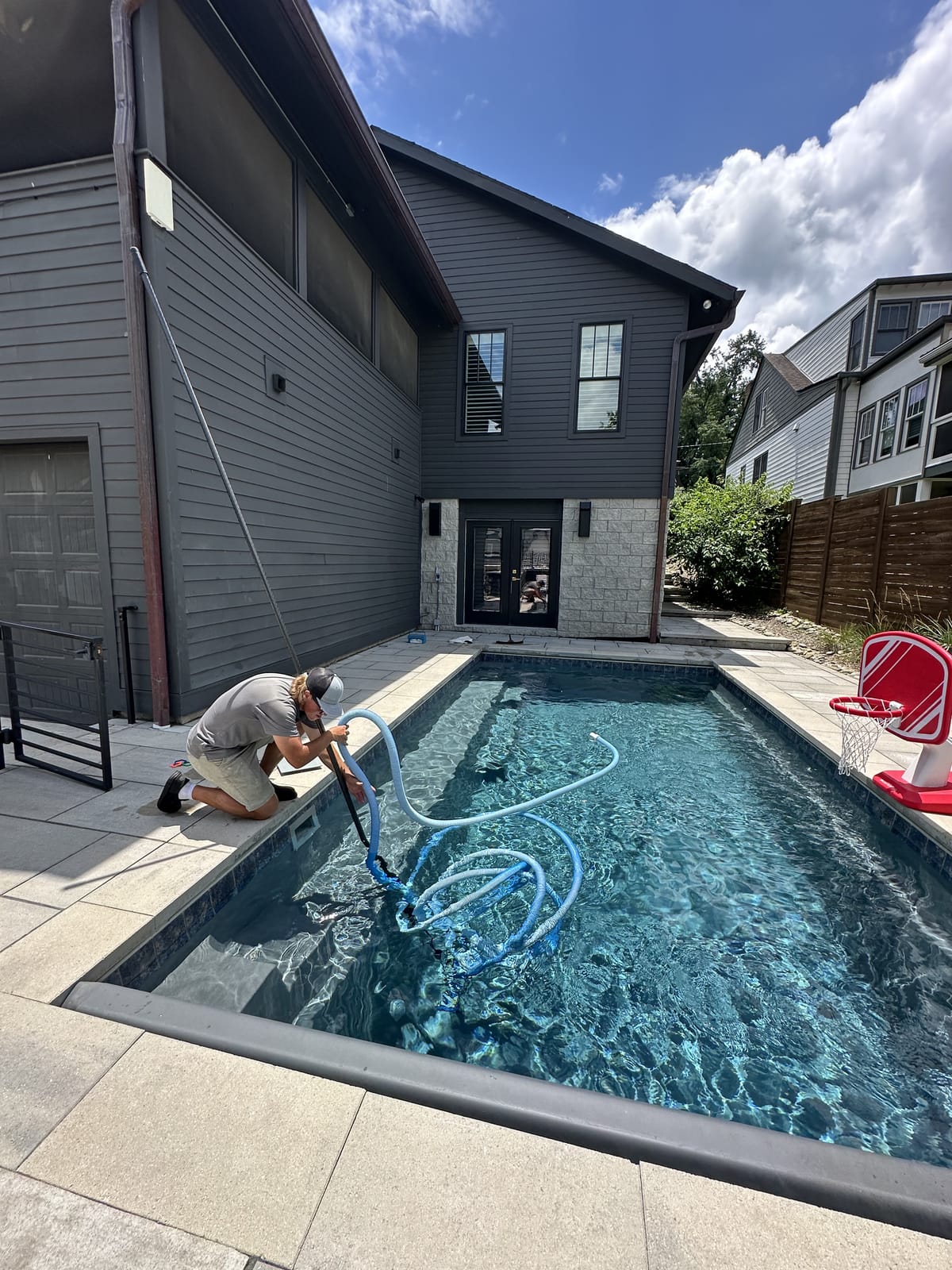 Bright Water technician vacuuming a pool during a weekly maintenance visit