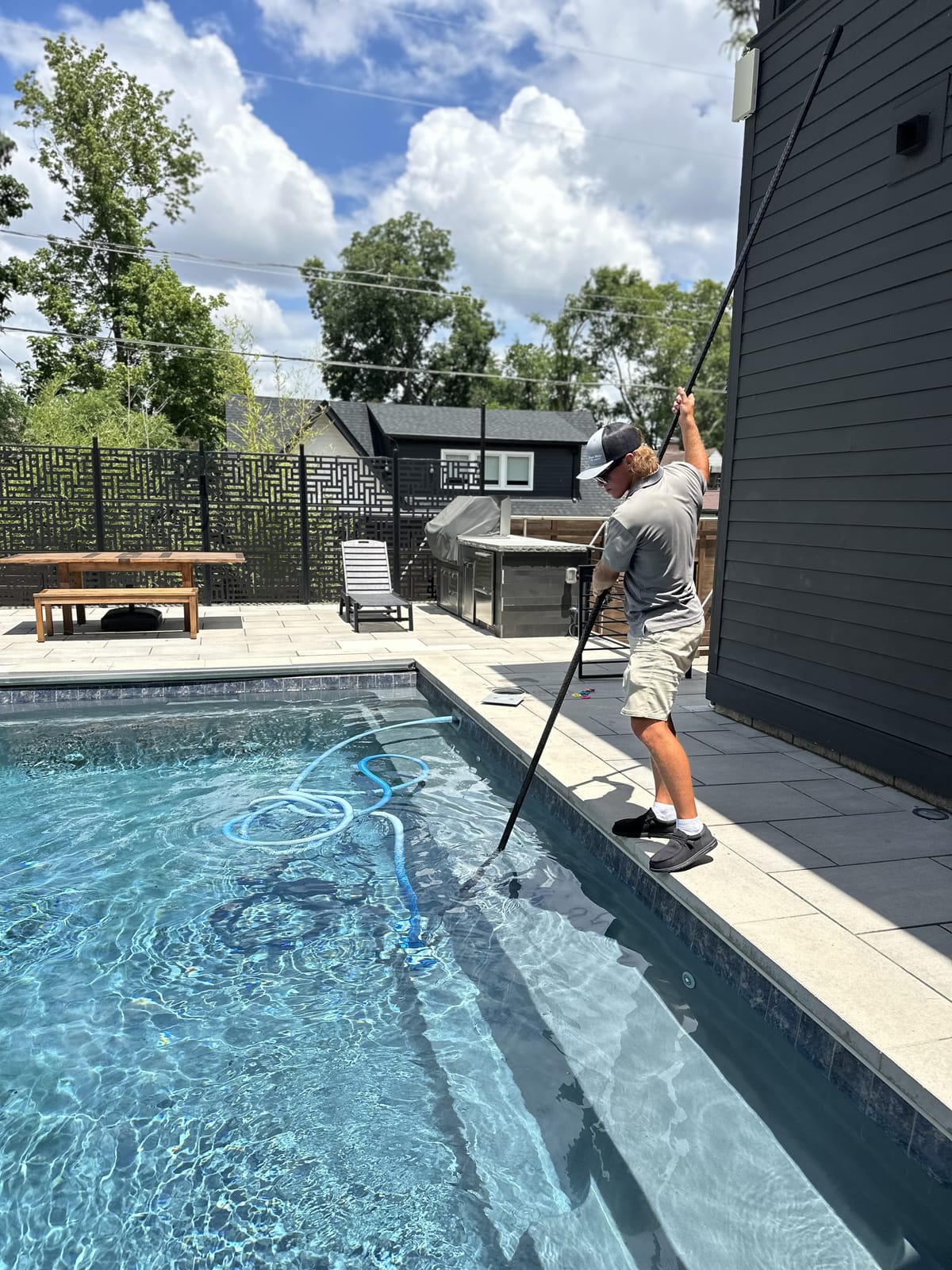 Bright Water technician vacuuming a pool during a service visit
